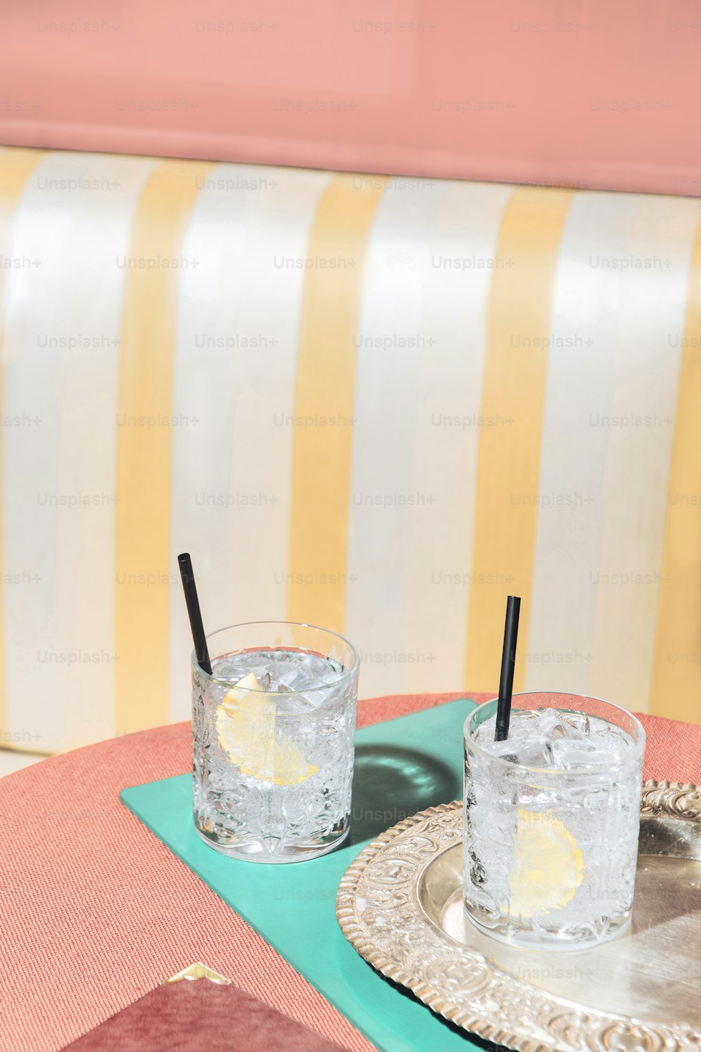Two glasses of gin and tonic on a table, into a pop-colored bar