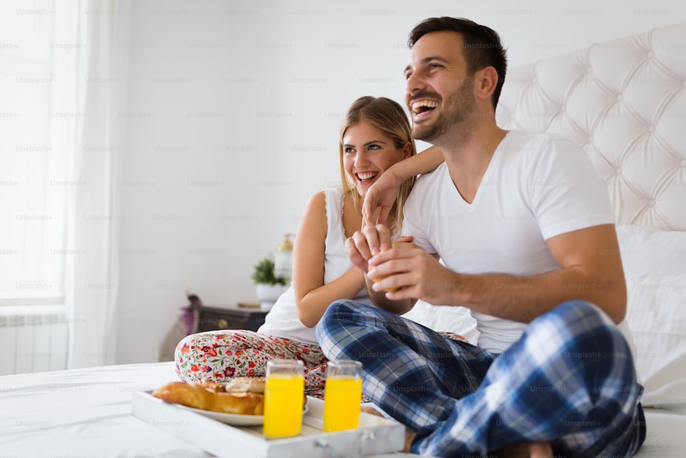 Young happy couple having having romantic times in bedroom