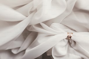 Anillos de oro de boda modernos en tela suave, imagen creativa. Composición contemporánea de accesorio elegante para boda, vista superior. Alianzas sobre tul en luz. Concepto de matrimonio
