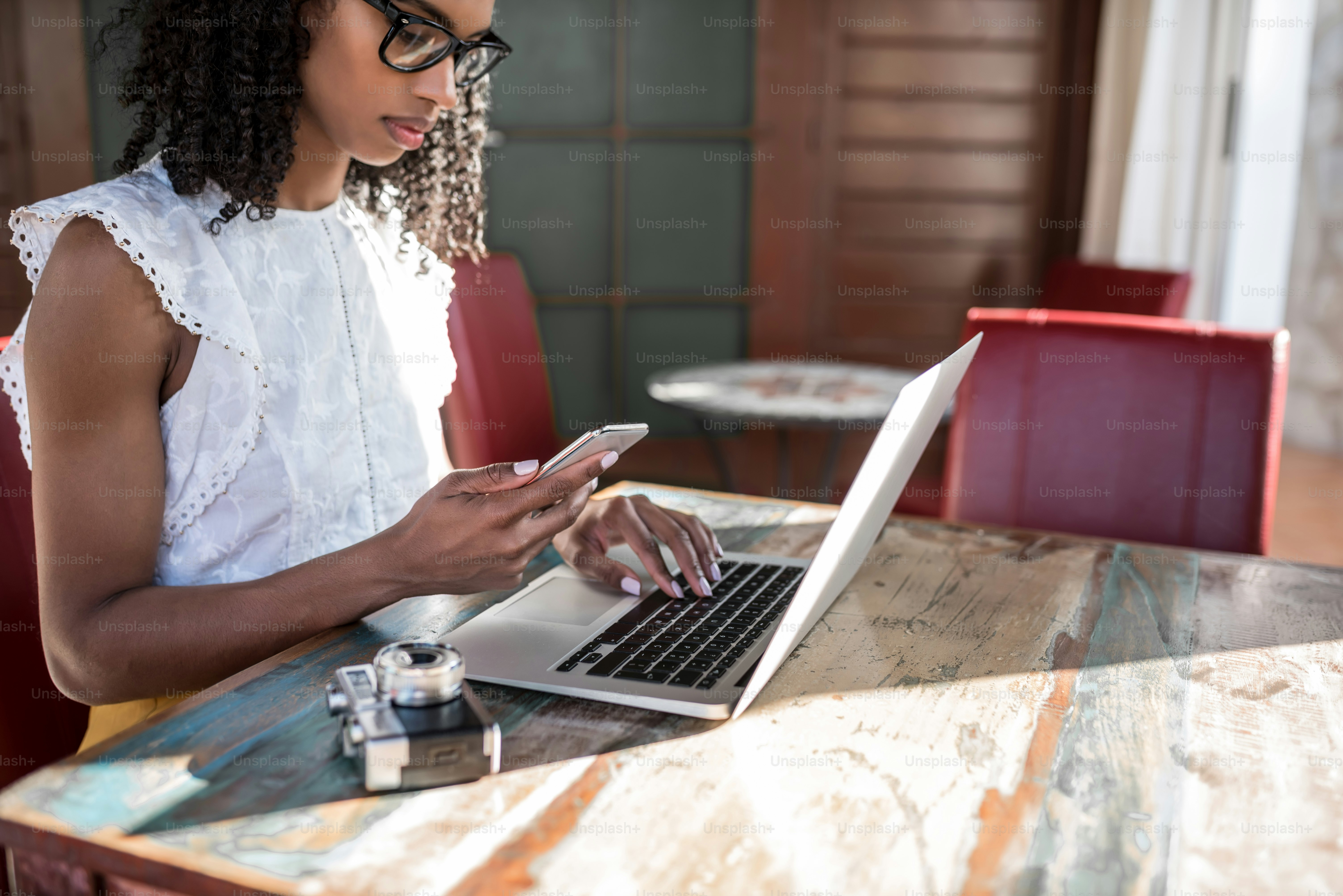 Businesswoman working from home on her computer and speaking on the mobile phone
