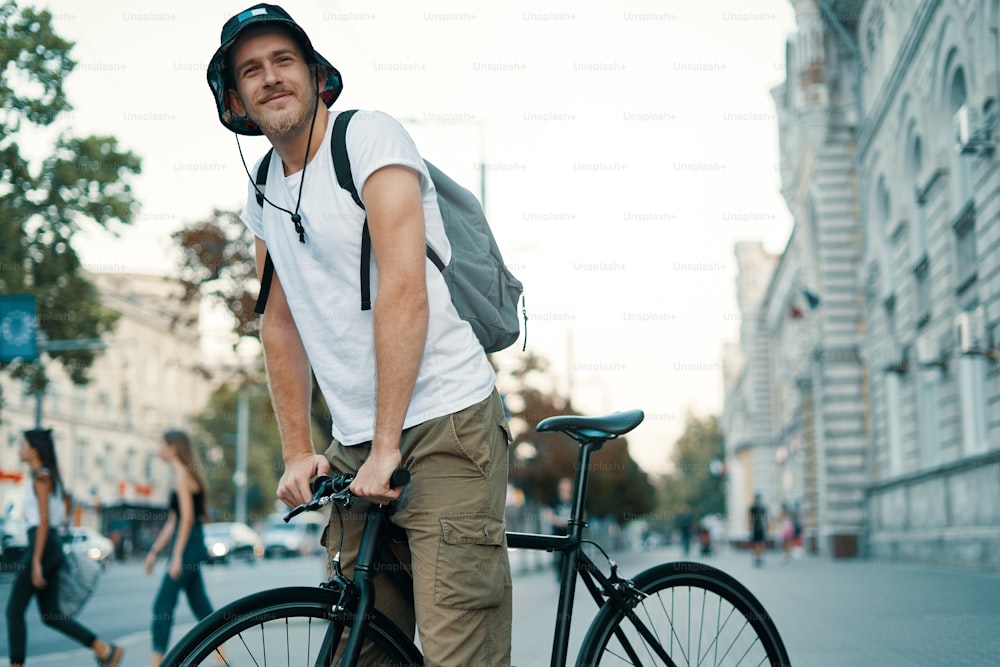 Un hombre montando en bicicleta en una vieja ciudad europea al aire libre. Estilo de vida, transporte ecológico, concepto de personas.