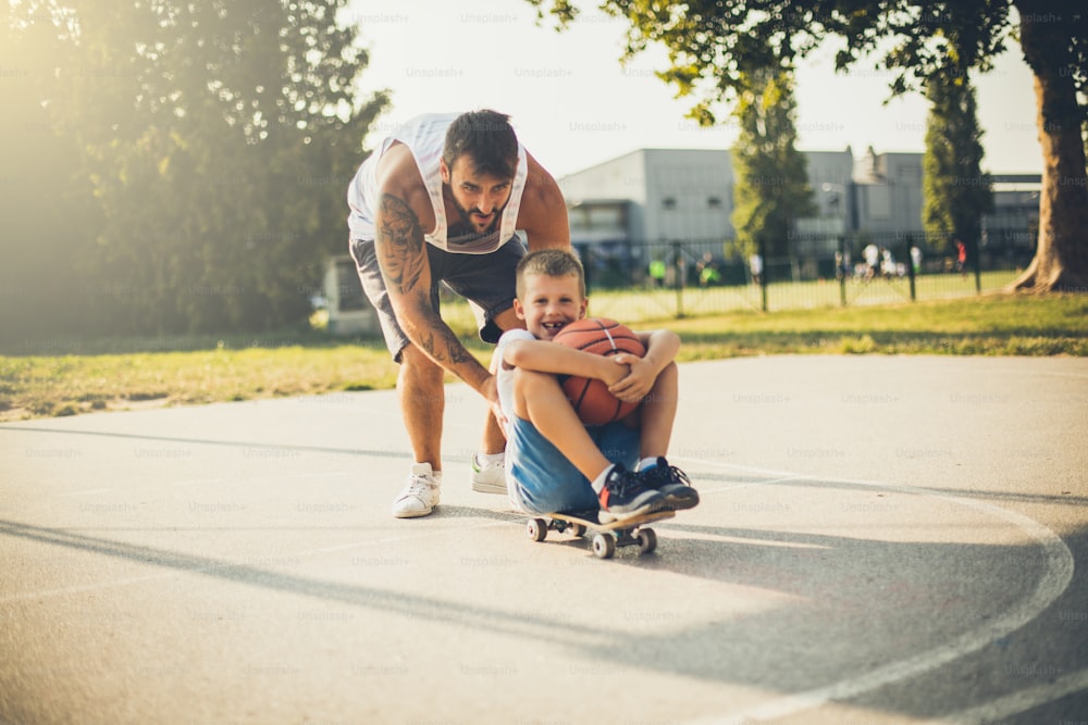 Boys stuff. Father and son have fun on skateboard.