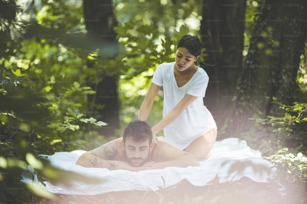 Woodland is perfect place for massage at nature.  Young couple.