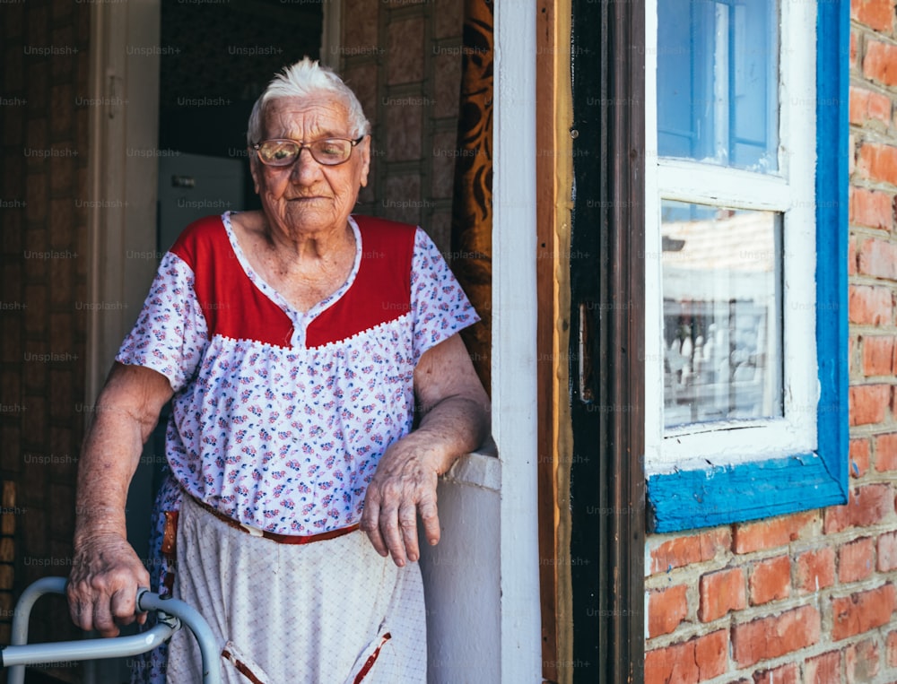 Schwarz-Weiß-Porträt einer alten faltigen hundertjährigen Frau. Eine lächelnde Großmutter mit großer Brille. Alter, Freundlichkeit und Weisheit