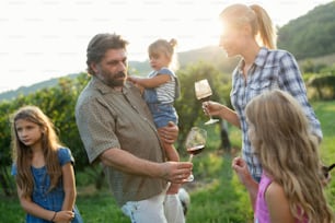 Familia de viticultores felices en el viñedo antes de la vendimia