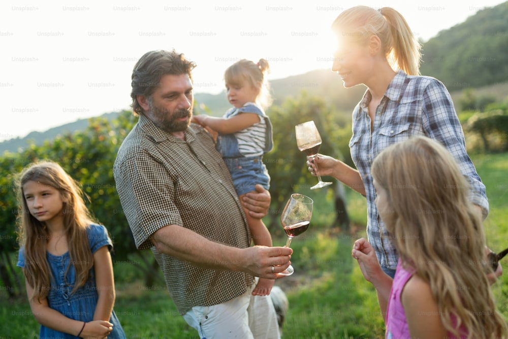 Familia de viticultores felices en el viñedo antes de la vendimia