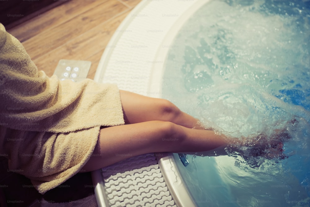 Woman with beautiful legs entering hot tub in spa resost