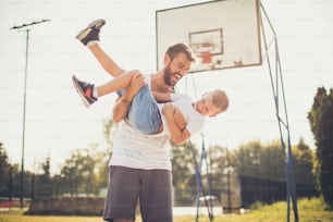El tiempo de papá siempre es divertido. Padre e hijo en cancha de baloncesto.