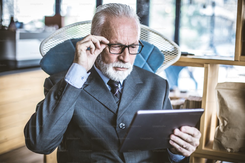 Senior businessman using digital tablet. Close up.