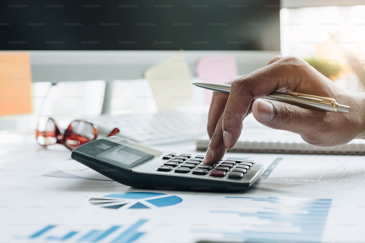 Expert-comptable travaillant sur son ordinateur et sa calculatrice pour la vérification de données financières