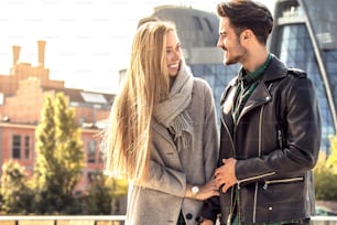 Young couple dating in the city. Blonde beautful woman and handsome man in fashionable clothes , autumn season.