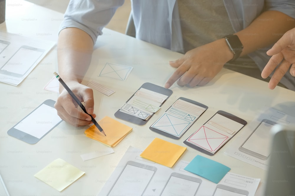 Equipo de diseño de UX, planificación gráfica creativa, desarrollo de aplicaciones, un prototipo de diseño de teléfono inteligente en papel.