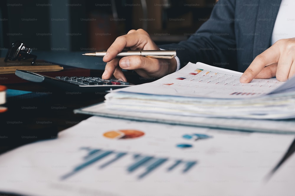 businesswoman using a calculator to calculate the numbers for financial document, finance accounting concept