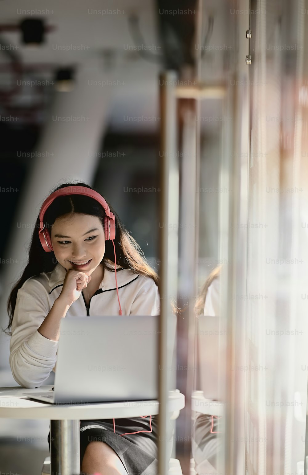 Pretty Asian girl listening music with her headphones in the cafe