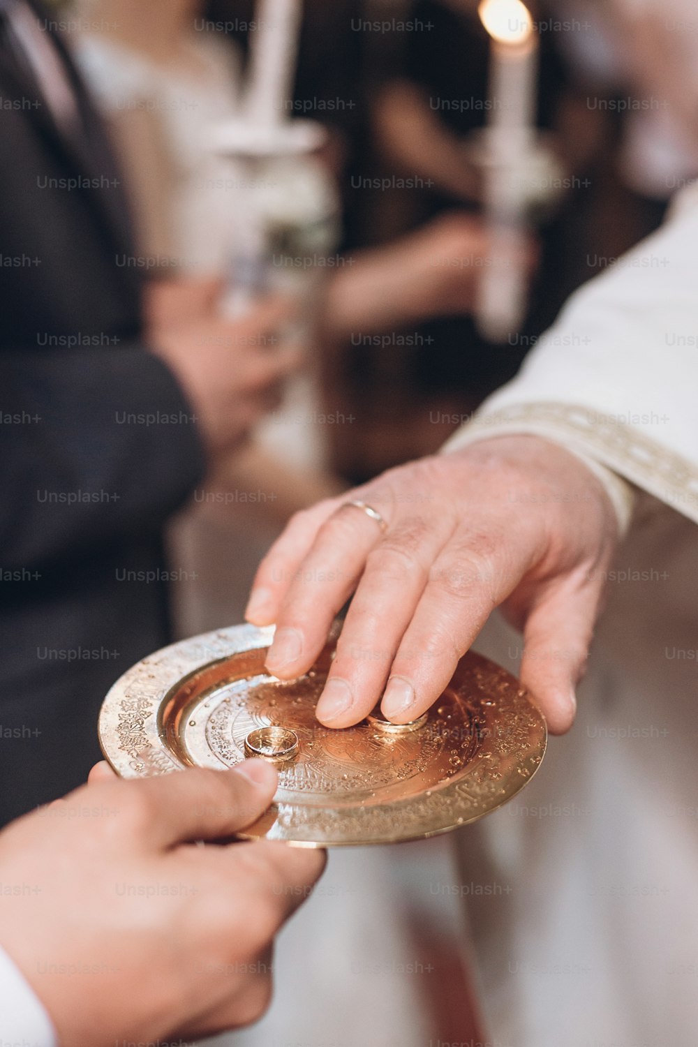 結婚式で教会のプレートに金の結婚指輪をゴールディング司祭。伝統的な宗教的な結婚式