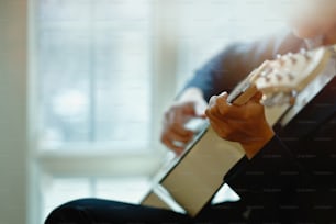 Foto cortada do homem tocando violão.