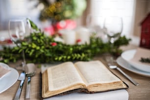 クリスマスの時期に自宅で夕食をとるために、テーブルセットの上で聖書の本を開きました。