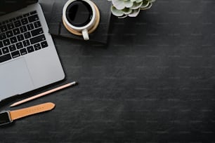 Dark leather desk with home office gadget and copy space.