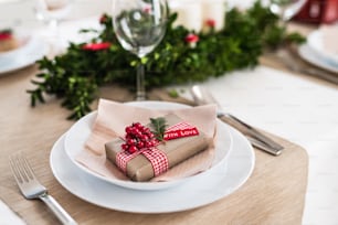 A close-up of a table set for a dinner at home at Christmas time.
