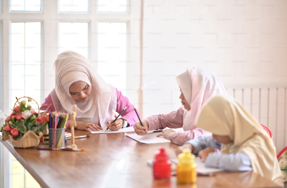 Young Asian muslim female teaching in art class