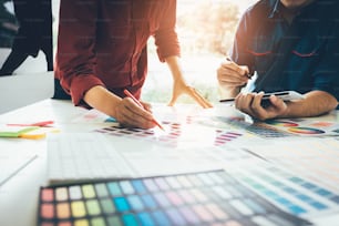 Colega de trabalho designer gráfico trabalhando com parceria escolhendo cor na mesa em escritório moderno.
