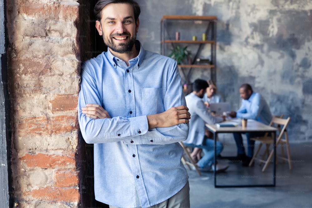 Happy smart business man with team mates discussing in the background