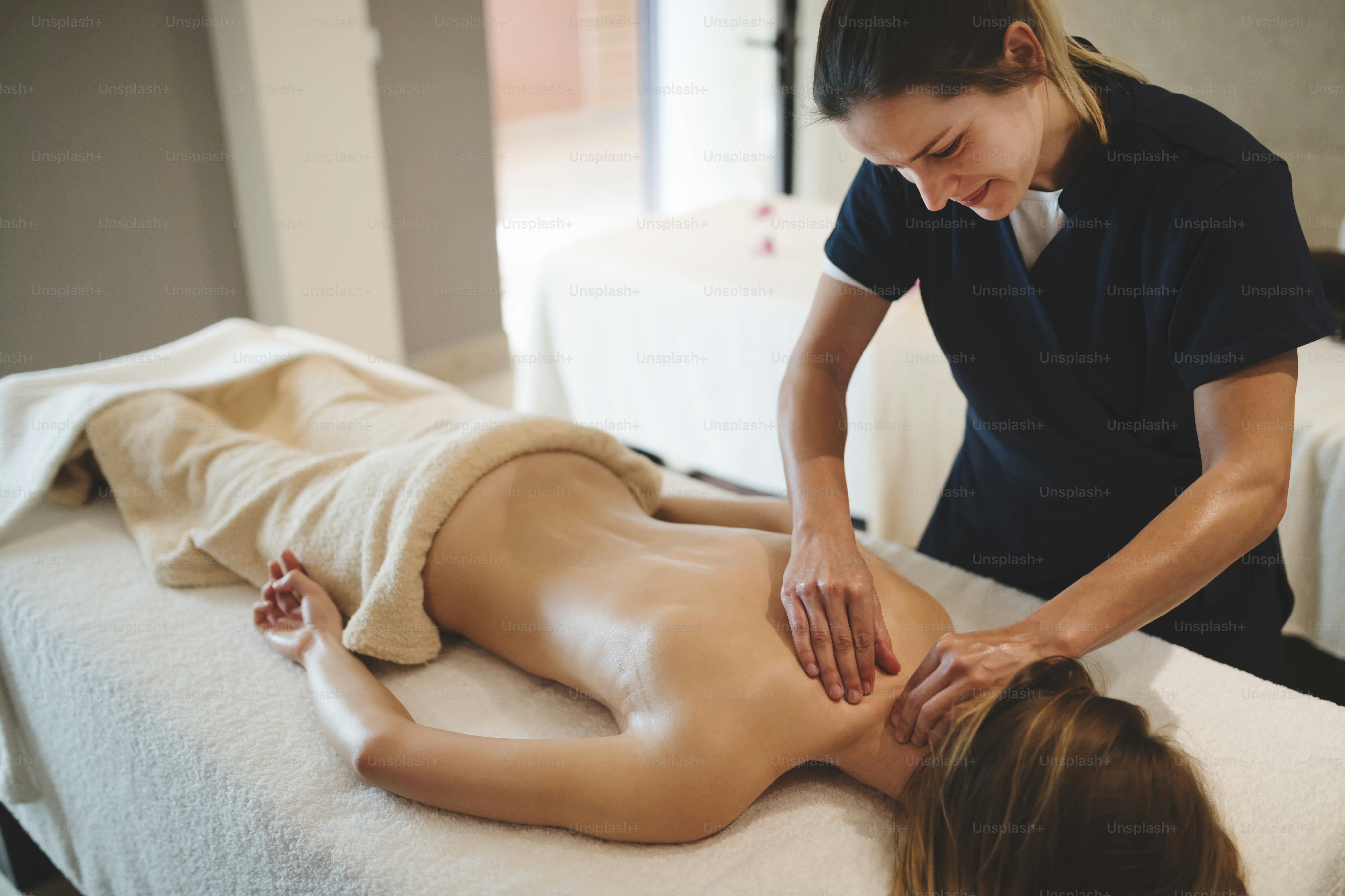 Tukang pijat memijat punggung wanita di resor spa