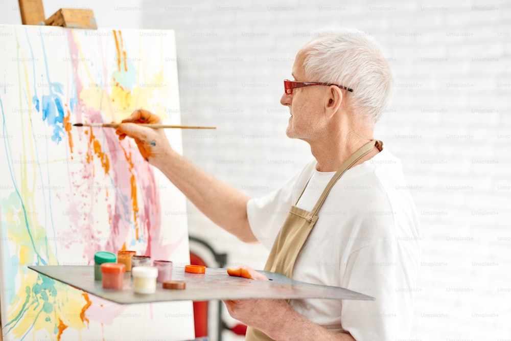 Close-up view of highly gifted painter while he is painting his picture.