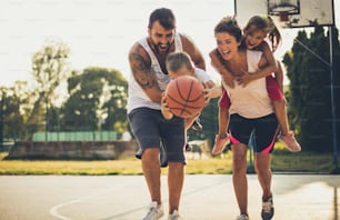 Catch the ball and go into the game. Family playing basketball.