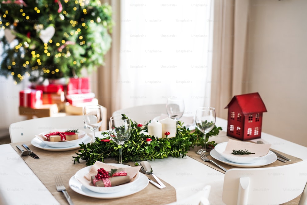 Una tavola apparecchiata per una cena per quattro persone a casa nel periodo natalizio.