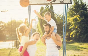 Team against the team, who is the winner? Family playing basketball. Close up.