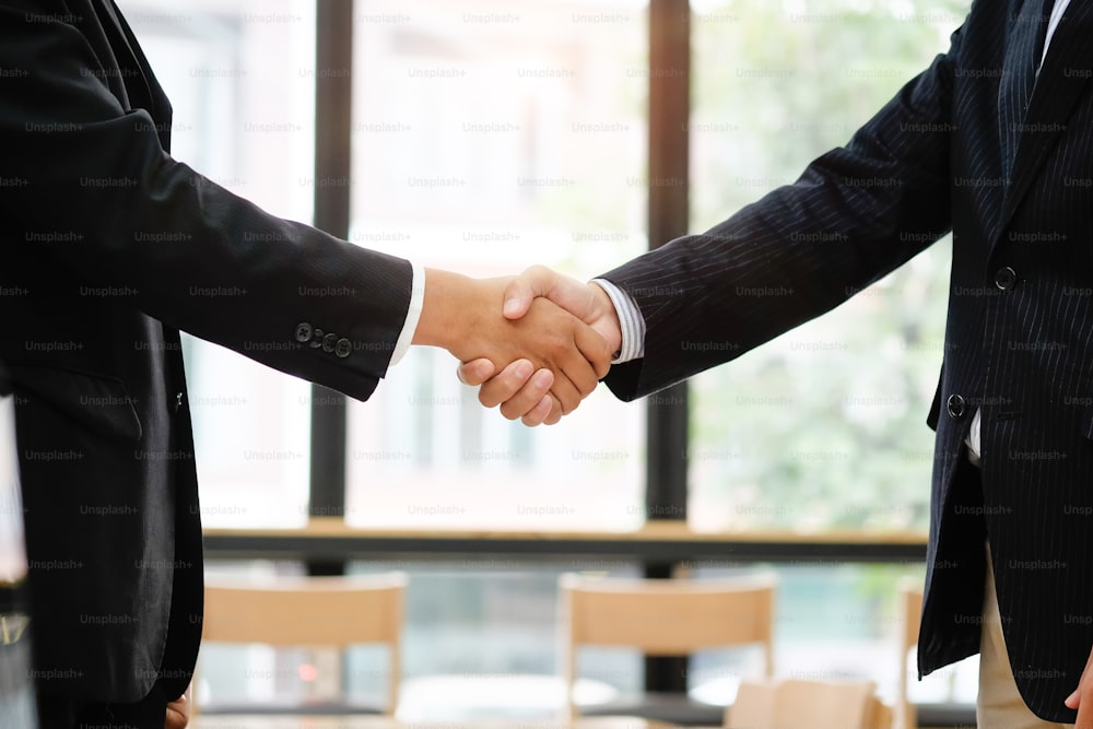 事業買収のコンセプトは、クロップドは、会議を終えて握手を交わすビジネスマンを撮影しました。