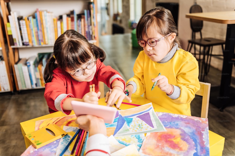 포괄적 인 유치원. 다운 증후군을 앓고있는 귀여운 아이들은 포괄적 인 유치원에서 공부하고 그림을 그리는