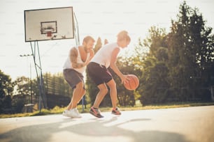 Ball for girl. Couple playing basketball.