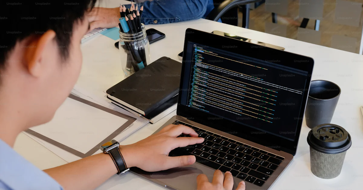 Un Programador Un programador masculino que trabaja con una computadora portátil y ...