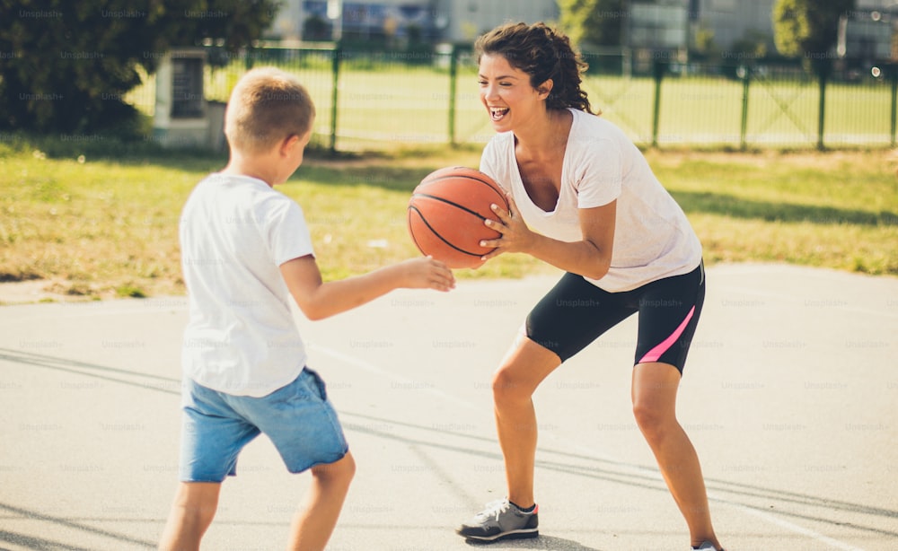 Sports lovers. Mother and son playing basketball.