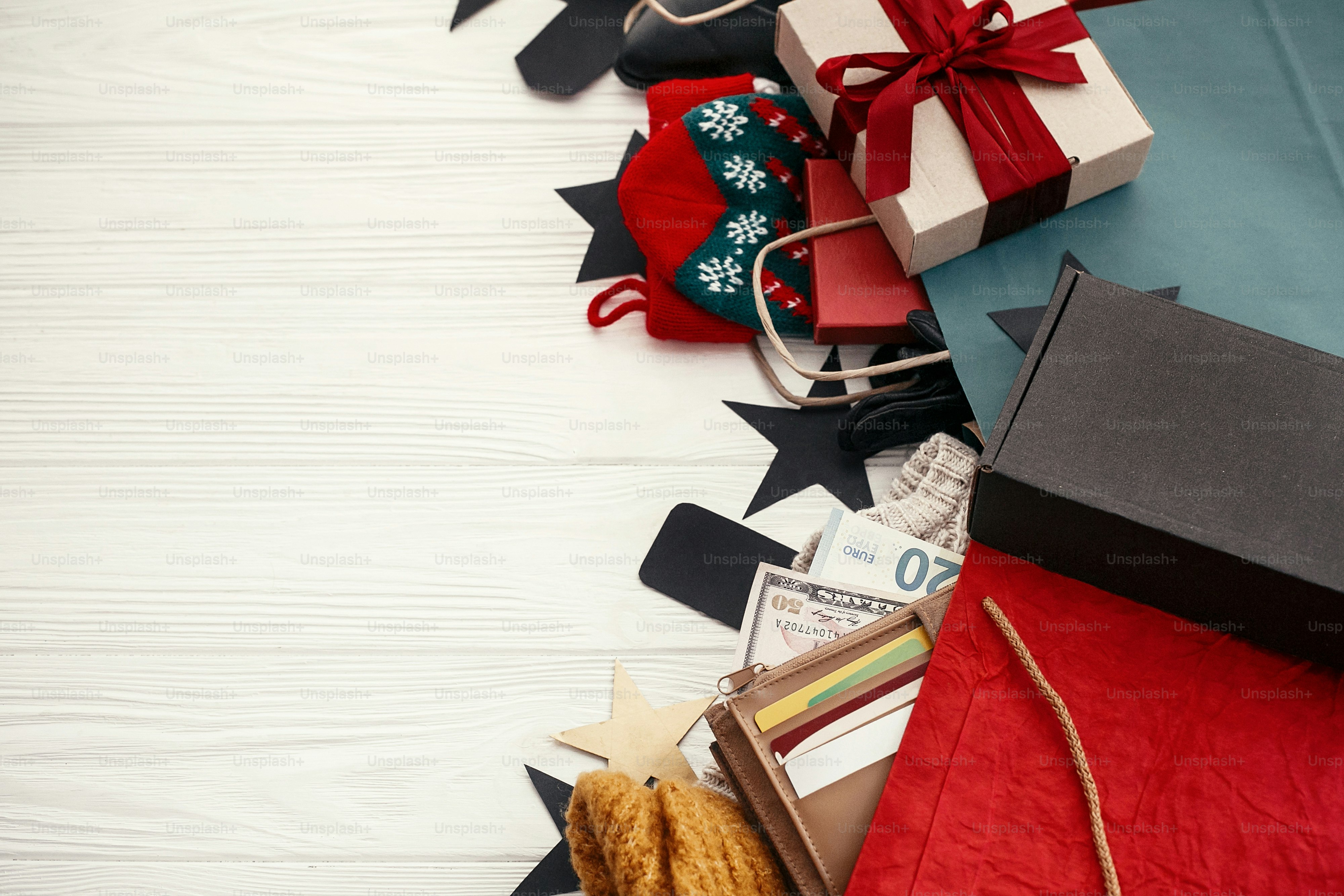 Christmas shopping and seasonal sale. Credit cards and money in wallet, paper bags with clothes, stockings,  tags, gift boxes on rustic wood. Special christmas offer discount. Space for text