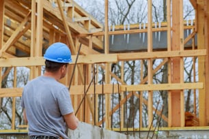 Ein Bauinspektor begutachtet ein neues Eigenheim auf einer Baustelle und prüft das neue Gebäude