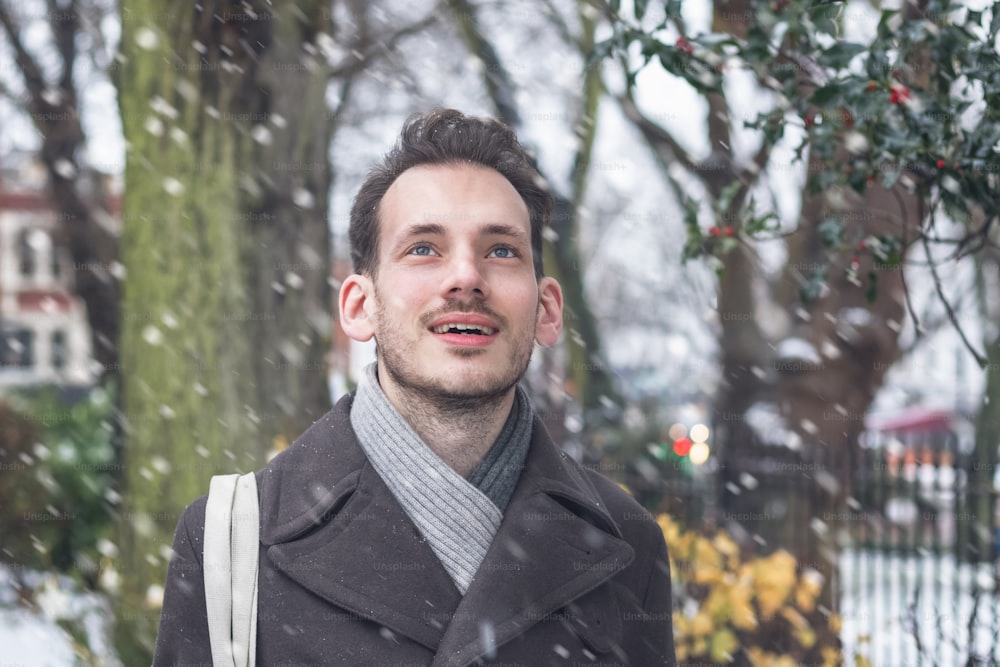 Retrato de un joven guapo en la nieve invernal