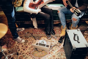 ホームスタジオでライブの練習をするミュージシャンたち。床にはラップトップとアンプ。