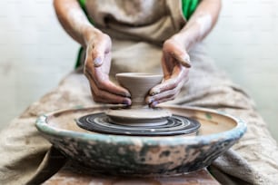 Cropped close up photo of workmanship handcraft artist lady in her workwear she sit inside workspace make ceramics product for sale by hands