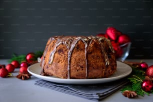 Christmas cake with chocolate icing on gray wooden background. Holiday decorations concept. Top view. Flat lay. Copy space