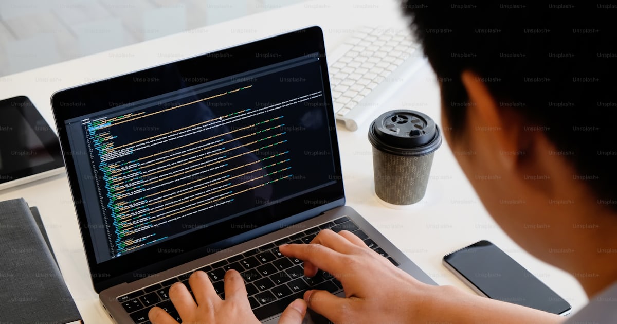 A male programer working with laptop and coding on computer. photo ...