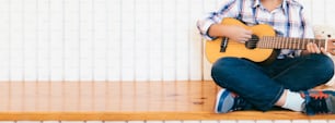 Niño tocando la guitarra en casa. Educación musical y clases extracurriculares.