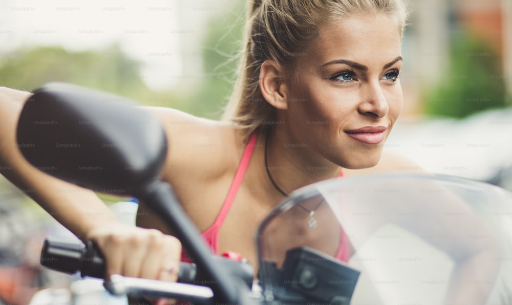 Listo y saludable para nuevas metas. Retrato de hermosas mujeres jóvenes montan su motocicleta.  Imagen de primer plano.