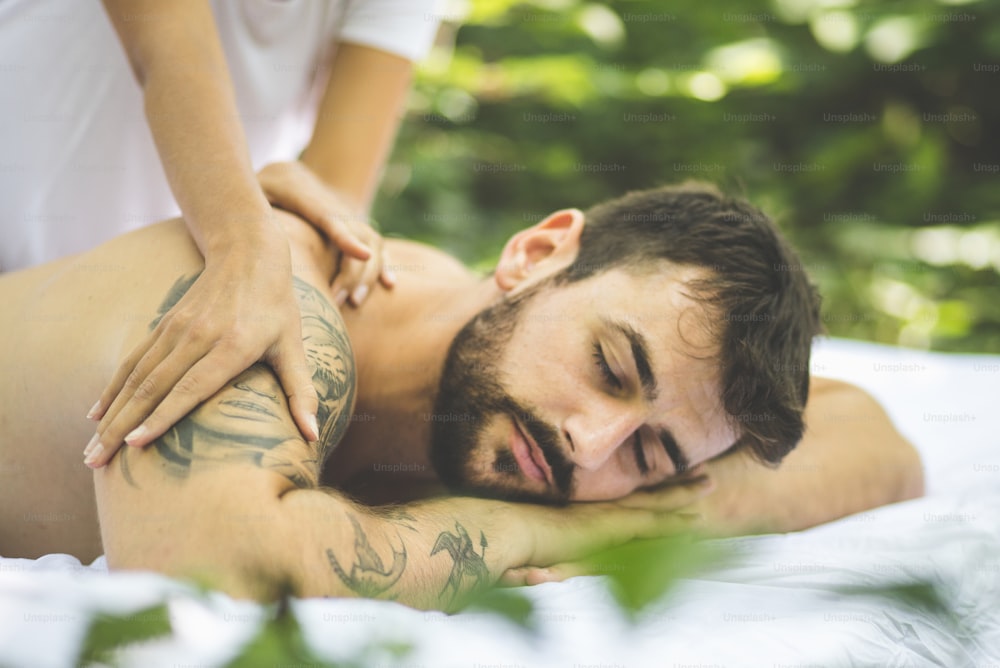 The road to total relaxation. Young men enjoy in massage. Outdoors.