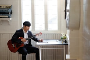 Song writer working, A man using tablet and guitar on artist workplace.