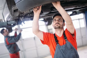 Car mechanics working at automotive service center together