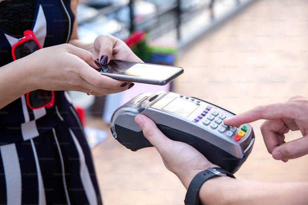 신용 카드 스 와이프 기계를 통한 여성 지불.