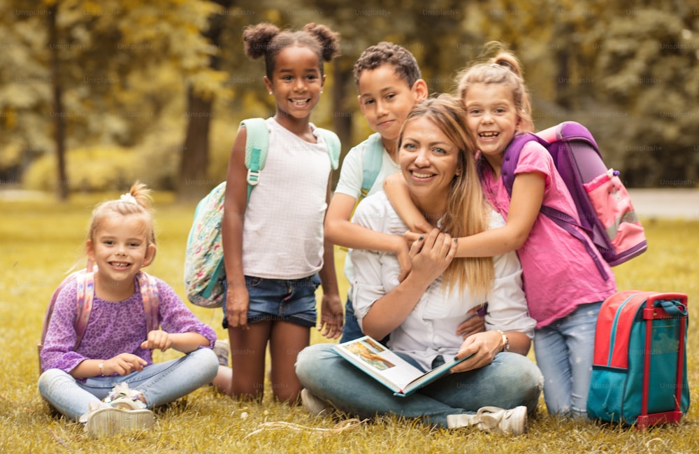 Children are the beauty of the world. Portrait of teacher and children in nature.  Looking at camera.